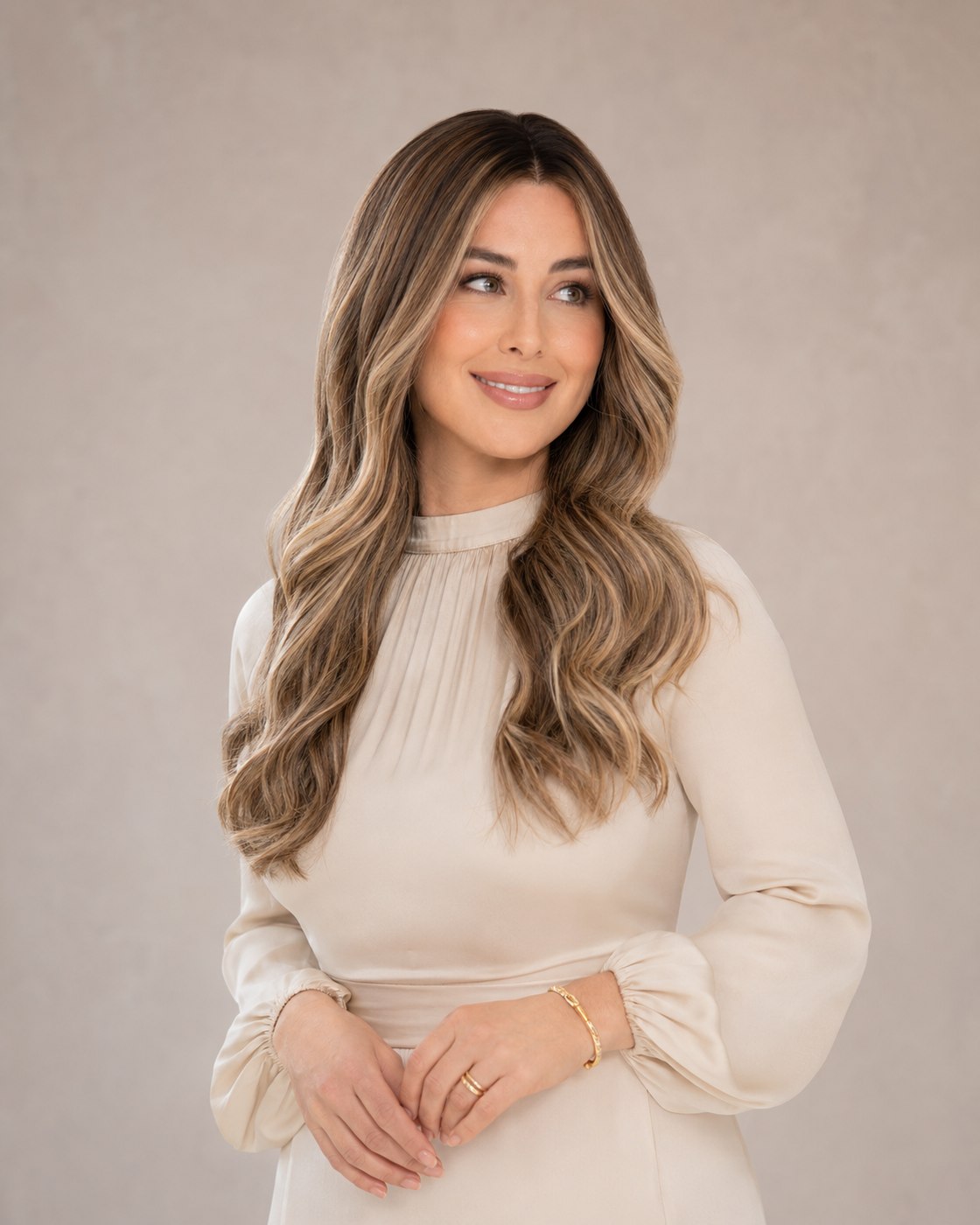 Woman modeling a caramel balayage sheitel with long, soft waves